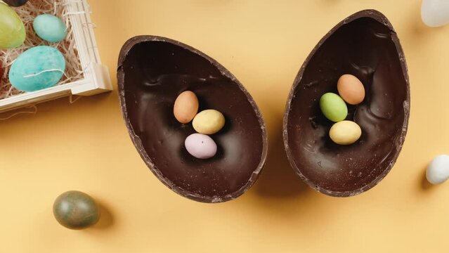 chocolate easter egg with surprise on yellow background 