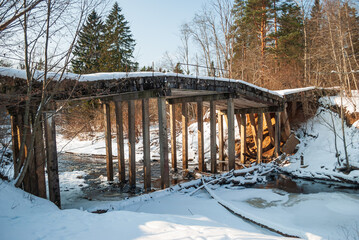 An old concrete bridge in a state of emergency on a sunny winter day.