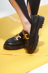 Naklejka premium Beauty stylish woman posing in fashion clothes in studio. Summer fashion, trendy shoes, casual style. Woman chooses shoes collection autumn spring 2022. Long slim beautiful female feet. 