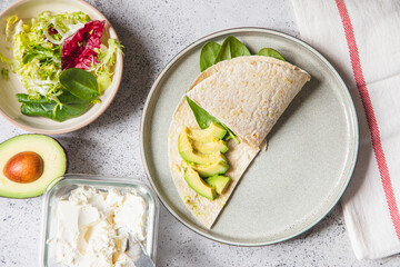 Cooking process for sandwich and ingredients. Process of prepare quesadilla with avocado, salmon, curd cheese and spinach. Trendy wrap hack. Step by step. Step 3