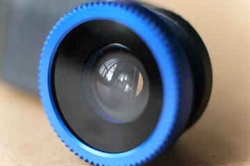 Macro External additional lens for smartphone on wooden table.