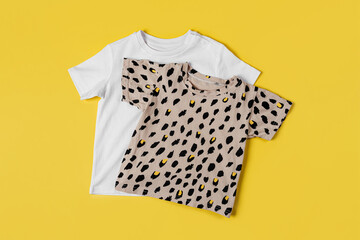 Childrens T-shirts on yellow background. Set of baby clothes  for spring, autumn or summer. Fashion kids outfit. Flat lay, top view