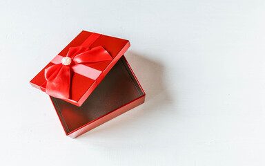 Red gift box  opened on white wooden table
