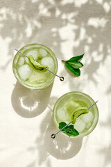 Summer cold drink and beverages. Lemonade with kiwi, mint  and ice in glass. Rinfreshment unalcolic cocktail. Selective focus.