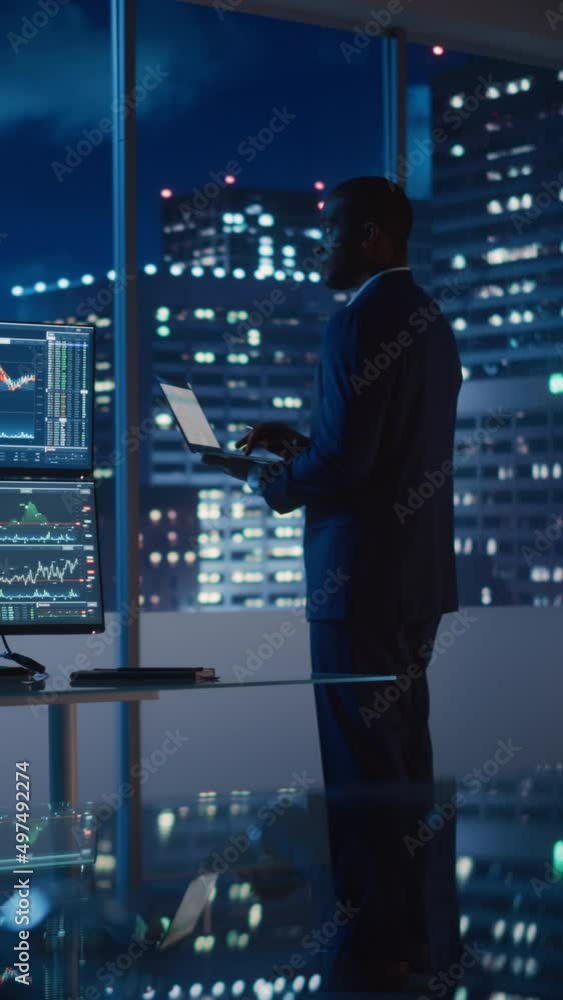 Poster Vertical Footage of Financial Analyst Using Laptop Computer, Standing Next to Multi-Monitor Workstation with Real-Time Stocks Charts. Businesswoman Working in Investment Bank City Office.