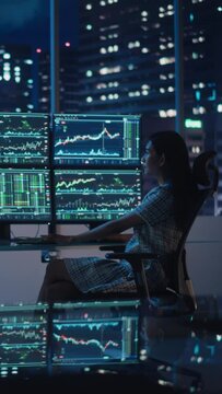 Vertical Portrait of a Financial Analyst Working on Computer with Multi-Monitor Workstation with Real-Time Stocks, Commodities and Exchange Market Charts. Businesswoman at Work in Investment Agency.