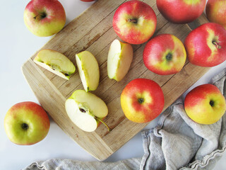 Bright apples and apple slices on a wooden board