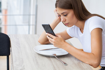 Pretty young woman obsessed with her smartphone and social networks