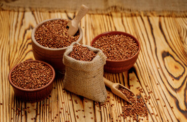Buckwheat groats in bowls and bags on a wooden background. High quality photo