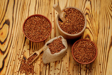 Buckwheat groats in bowls and bags on a wooden background. High quality photo