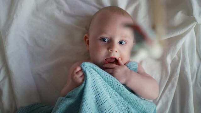 Little cute causian baby boy, smiling at camera, boy looks at the toy and is delighted. 