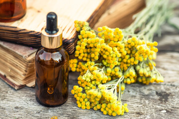 Bottles of healthy tincture or infusion, mortar and bowls of medicinal herbs. july arenarium,...