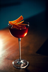 Vertical shot of a refreshing cocktail on a wooden table in dim lighting. © Spolsino Gianluca/Wirestock Creators