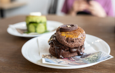 Close up of chocolate scone served on plate. Scones are small nibbles that are fairly plain on their own, but are classically eaten with jam and clotted cream.