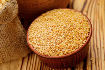 Wheat groats in bowls and bags on a wooden background. High quality photo