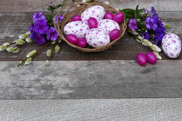 Nest mit Ostereiern und Blumen mit Textfreiraum.