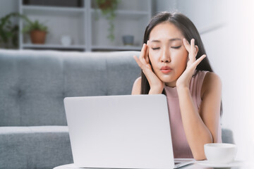 A young woman is stressed from using a computer.