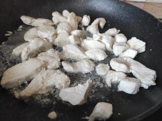 frying chicken pieces in pan