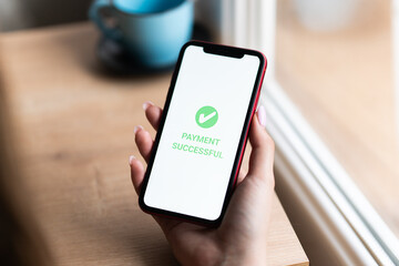 A Woman's hand holds a smartphone on screen with the message money sent and received. Concept of financial transactions with mobile devices. Closeup, money, transfer, phone, Payment. Cafe background
