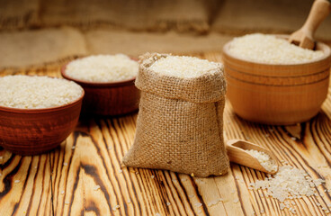 Fototapeta na wymiar Polished round rice in bowls and bags on a wooden background. High quality photo
