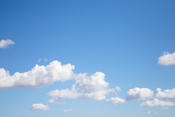 Bright blue sky with many beautiful white clouds for background or wallpaper. The beauty of nature for graphic design, natural beauty, ecology and clean air. Natural textures.