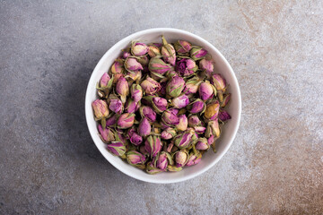 White bowl with dried rose buds for herbal tea