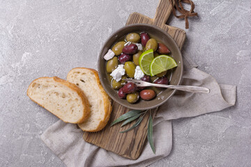 Bowl of delicious olives with Feta cheese in oil and bread