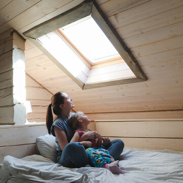 Portrait of enjoy happy family mother and little girl hugging, smiling, playing and having good time in a cozy room at home.