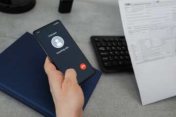 Phone call from unknown number. Scam, fraud or phishing with smartphone concept in the office. Man answering to incoming call. Hoax person with fake identity. 