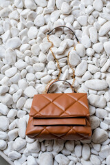 Stylish women's brown handbag. Trendy outfit woman with brown bag. Girl with bag over his shoulder outdoors. Shoulder Bags for Women. Fashion look woman outfit. Close-up.