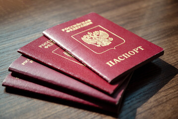 Stack of Russian passport documents on wooden table surface