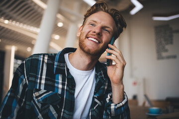 Young caucasian guy talk on smartphone in office