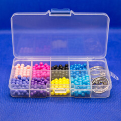 Container organizer with cells for small items for women's needlework and creativity.