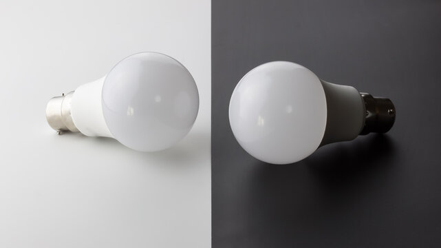 Two led bulbs, next to each other. Light bulbs on grey and white split background - with copy space