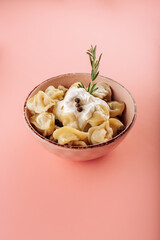 dumplings in a plate on a pink background