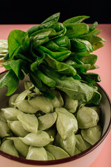 green dumplings on a pink background