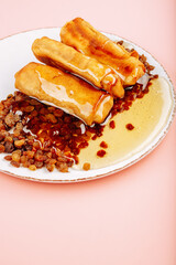 pancakes with honey on a pink background