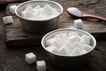 Fototapeta na wymiar White Sugar cubes in aluminium bowl on wooden plate