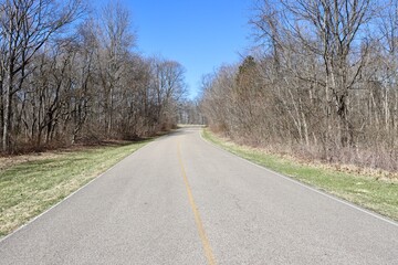 Fototapeta premium The long empty road in the countryside on a sunny day.