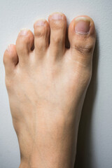 The foot and long nail toes on white concrete background. Long n