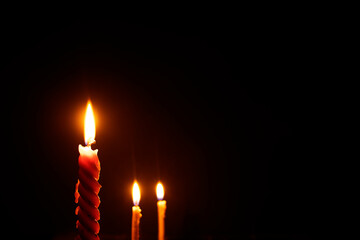 Light three candles in a dark room.