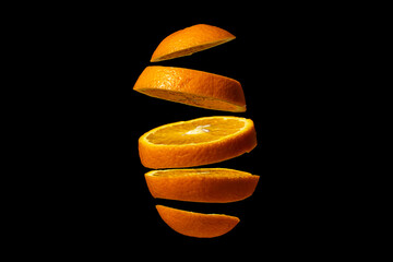 Sliced orange isolated on black background. Orange cut into round slices. Ripe citrus fruit