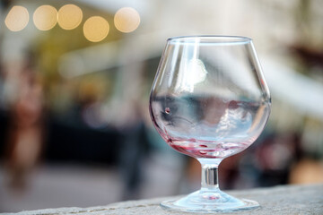 Empty glass dirty from red wine. Wine Glass with Blurred Lights.