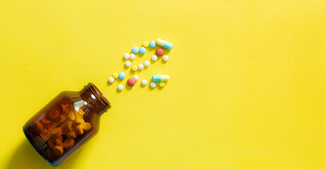 pills and bottles on yellow background,white pill and white bottle with copy space on yellow background health and medical concept