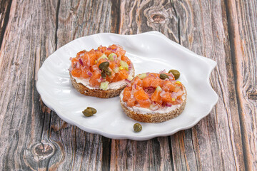Salmon tartar over bread served capers