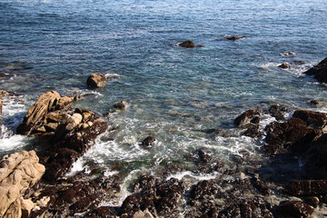Rocky shore washed by the tide on a sunny day