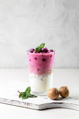 Yogurt, granola with nuts and cherries in a transparent glass. Light and healthy breakfast. Copy space