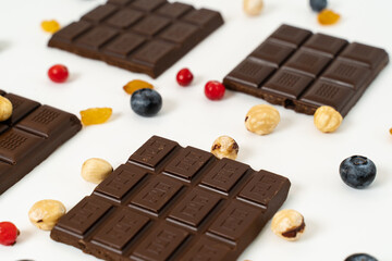 Handmade chocolate bars with fruits, berries and nuts on a white background.