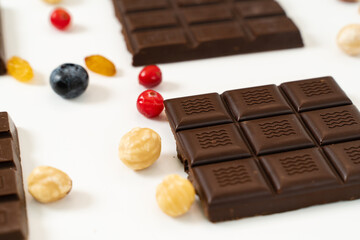 Handmade chocolate bars with fruits, berries and nuts on a white background.