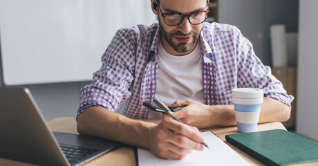 Millennial businessman working at desk in office